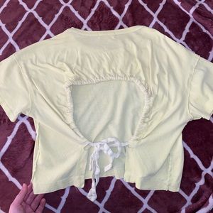 A urban outfitters distressed yellow T-shirt with open back.